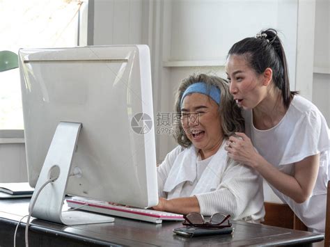 成年女儿帮助年迈的母亲使用电脑高清图片下载-正版图片506675468-摄图网