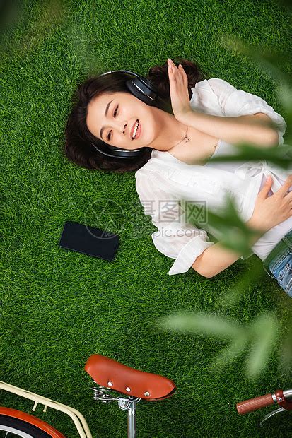 无忧无虑选择对焦摄影躺在草地上听音乐的青年女人高清图片下载-正版图片501910629-摄图网