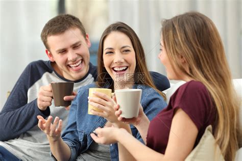 三个快乐的朋友聊天并大笑坐在家里客厅沙发上坐在高清图片下载-正版图片304507319-摄图网