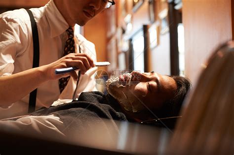 发廊理发师为男人提供理发剃须等服务高清图片下载-正版图片502091238-摄图网