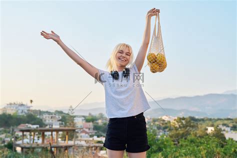 一名少女带着农场有机橙子的环保网眼袋高清摄影大图-千库网
