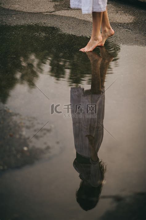赤脚走过的水坑里的女人 高清摄影大图-千库网