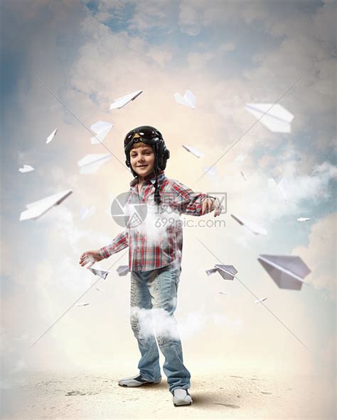 戴着飞行员帽子的小男孩飞行员头盔里的小男孩的形象,背景纸飞机高清图片下载-正版图片300301412-摄图网