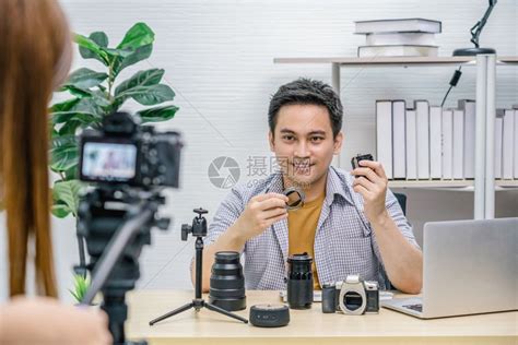硬件男人营销亚洲Vlogger男子满意每个媒体的相机镜头摄像影机拍视频并用笔记本电脑直播通过社交媒体频道vlog和impactr高清图片下载 ...