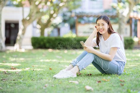 坐在校园草坪上玩手机的女生高清图片下载-正版图片500635979-摄图网