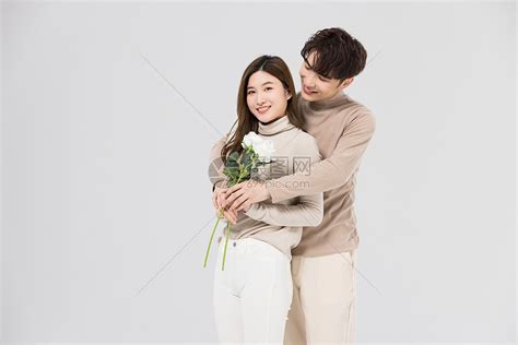 韩系情侣亲密拥抱手拿玫瑰花高清图片下载-正版图片502357478-摄图网