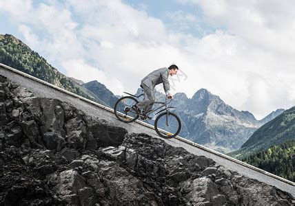 骑自行车下坡的商人自然景观与复制空间穿西装的男人在山路上骑自行车蓝天背景的骑自行车者健康的生活方高清图片下载-正版图片504010803-摄图网
