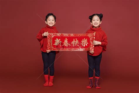 双胞胎小女孩姐妹新年拿春联高清图片下载-正版图片501801217-摄图网
