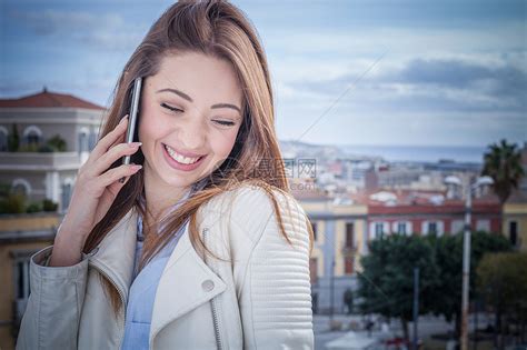 女青年在屋顶上用智能电话聊天高清图片下载-正版图片501849005-摄图网