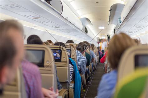 飞机内部，乘客坐在等待起飞的座位上。高清摄影大图-千库网