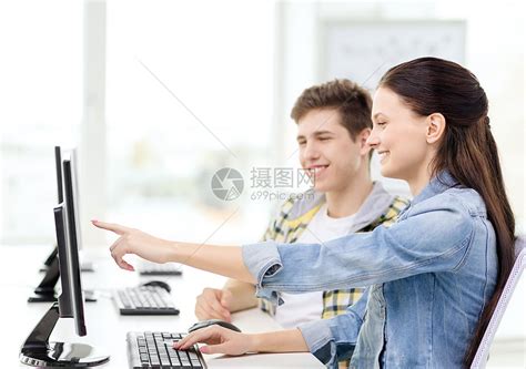 教育技术学校理念计算机两个微笑的学生,女孩指着屏幕高清图片下载-正版图片300815252-摄图网