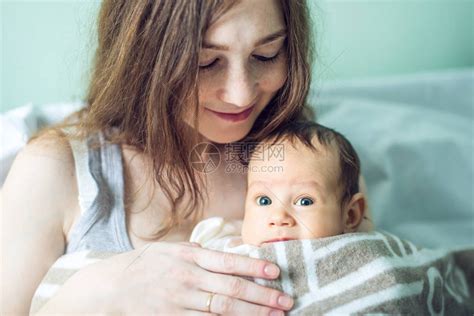 快乐有爱心的母亲在卧室里抱着男婴母柔情与家庭高清图片下载-正版图片502529094-摄图网