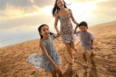 年轻母亲牵着两个孩子在沙滩上奔跑高清图片下载-正版图片507635088-摄图网