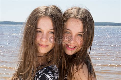 漂亮的双胞胎少女在沙滩上玩耍高清图片下载-正版图片502535374-摄图网