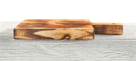 Tablero de madera sobre un mantel contra el fondo blanco. | Foto Premium