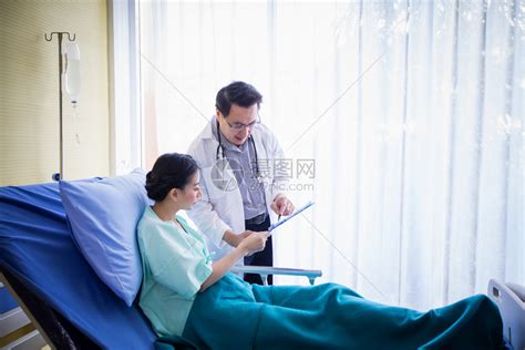 诊断外科医生向躺在院床上的一位女病人询问和解释情该名女人在医院卧床治疗高清图片下载-正版图片308050229-摄图网