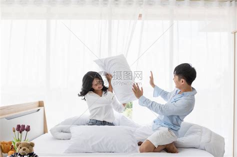 亚洲情侣一起在床上调情他们在卧室里玩枕头搏高清图片下载-正版图片506119993-摄图网