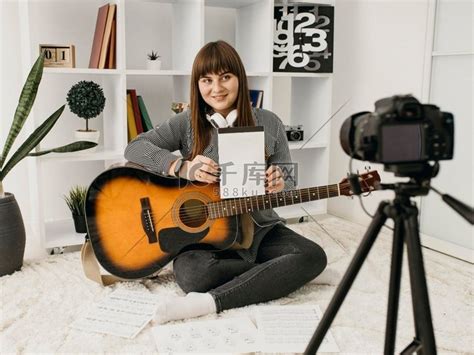 女博主带着相机在家直播吉他课高清摄影大图-千库网