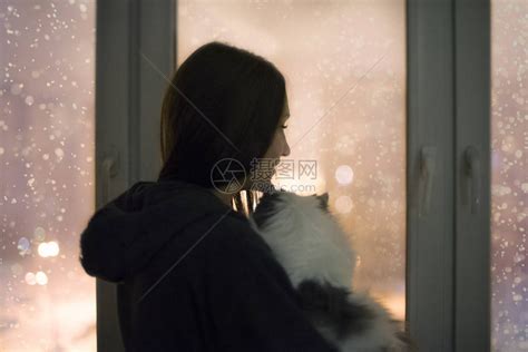 小孩在冬天带着雪景向窗外望着高清图片下载-正版图片502521469-摄图网