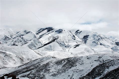一个孤独的旅行者正穿过暴风雪，背景是雪山。视频素材_ID:VCG42N492433886-VCG.COM