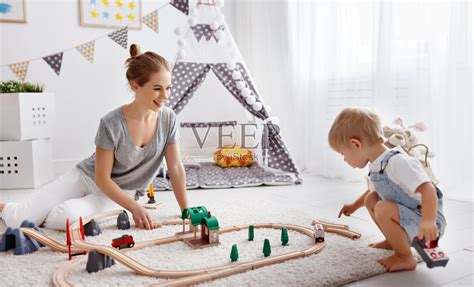 快乐的家庭妈妈和孩子儿子在玩具铁路玩在游戏室照片摄影图片_ID:313451110-Veer图库