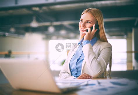 年轻女代理人通过办公室的电话与客户通话高清图片下载-正版图片503054840-摄图网