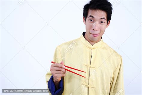 一个饥肠辘辘地拿着筷子的年轻人,摄影素材,汇图网www.huitu.com