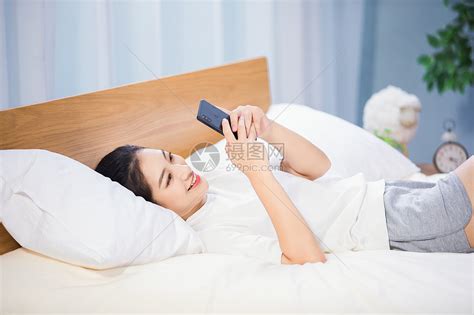 女性躺在床上玩手机高清图片下载-正版图片501372896-摄图网