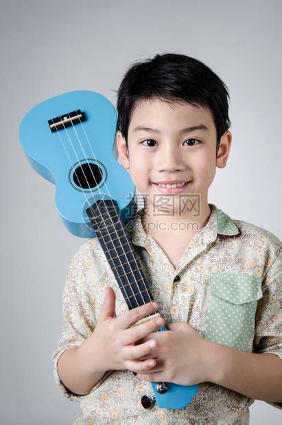 亚洲可爱的男孩和他的ukulelele高清图片下载-正版图片503600505-摄图网
