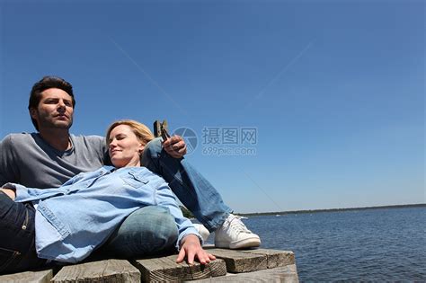 在湖边放松的情侣女性夫妻胡须文件说谎妻子休息白色拥抱棕色高清图片下载-正版图片321255858-摄图网
