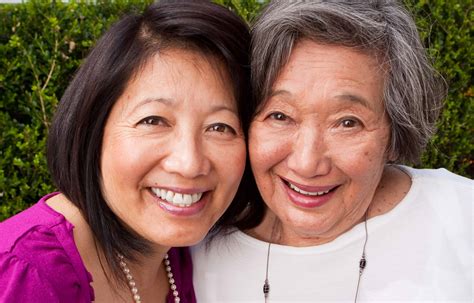Smiling mature Asian mother and her adult daughter.