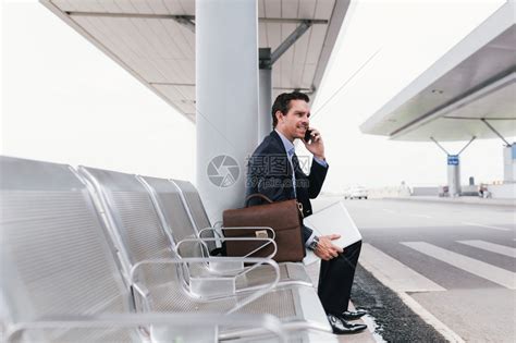 白人商坐在机场巴士站打电话高清图片下载-正版图片504820809-摄图网