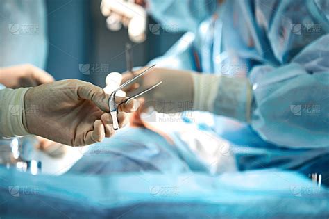 在手术室里，外科医生的双手正握着手术工具。特写，美丽的光线，现代医学，拯救生命