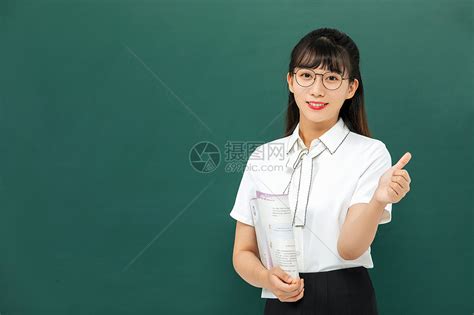 年轻的女教师在学校拿着地球仪高清摄影大图-千库网