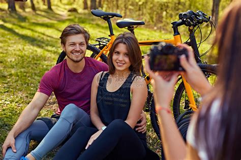 一对骑山地自行车的夫妇用手机拍摄自己的低角度照片。高清摄影大图-千库网
