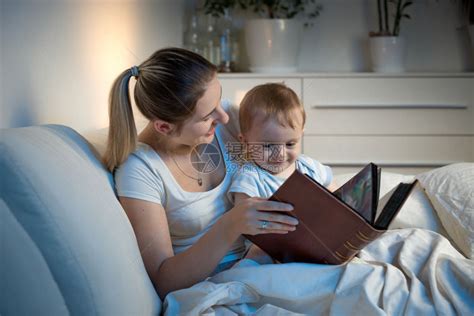 美丽的母亲在睡觉前微笑着读故事给儿子看高清图片下载-正版图片304282009-摄图网
