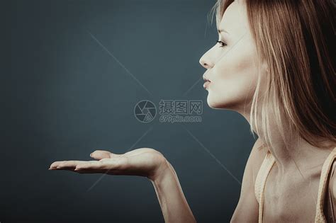 轻迷人的金发轻女人送手吻工作室拍摄的灰蓝色背景高清图片下载-正版图片300888119-摄图网
