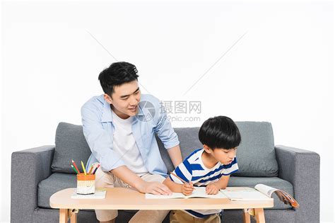 沙发上父亲辅导孩子写作业高清图片下载-正版图片500957528-摄图网