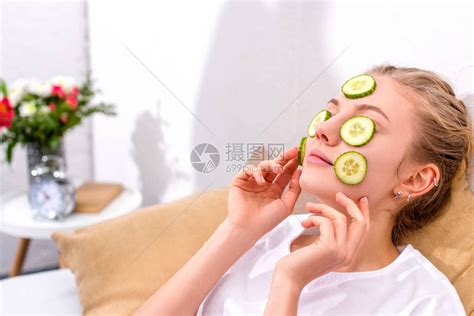 年轻女子在家里用黄瓜片敷脸高清图片下载-正版图片503373939-摄图网