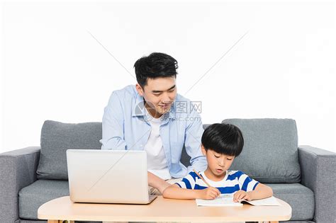 沙发上父亲辅导孩子写作业高清图片下载-正版图片500957519-摄图网