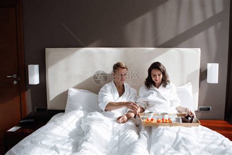 男人和女人在床上吃早餐吃着一大盘食物在酒店房间快高清图片下载-正版图片506390538-摄图网
