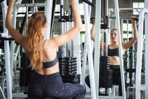 年轻有吸引力的健身女子在健身房里用机器和哑铃进行锻炼个人运动为健康的生活概念而使高清图片下载-正版图片506671902-摄图网