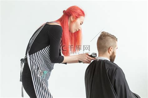 美发师、造型师和理发店概念 — 年轻女发型师要给男人剪头发高清摄影大图-千库网
