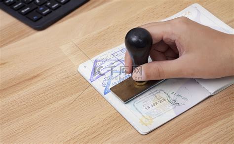 出入境管理人员将在机场的护照上盖上抵达章。高清摄影大图-千库网