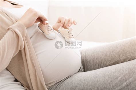 怀孕妇肚子上未出生婴儿的小型鞋子空闲间高清图片下载-正版图片505921183-摄图网