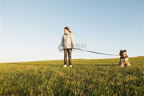 一个女孩牵着狗在森林散步图片下载 - 觅知网