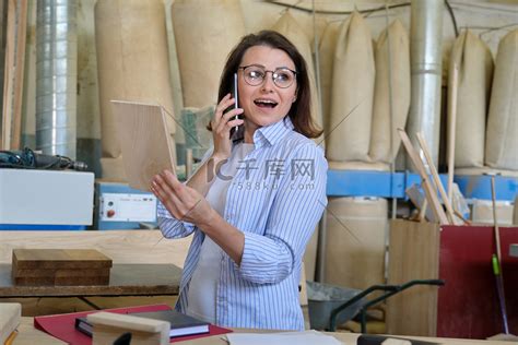 在木工车间工作的女木匠设计师打电话高清摄影大图-千库网