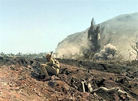 1945年2月-3月间，硫磺岛战役，一名美海军陆战队员躲避爆炸的冲击波，远处的山就是硫磺岛的制高点-折钵山，整座山都被日军改造成一个大碉堡。