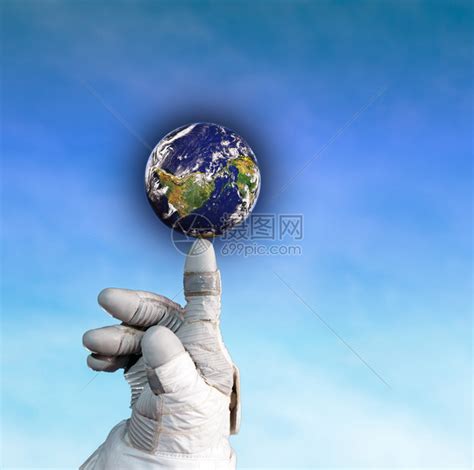 一位宇航员手握着地球的手在蓝天背景上高清图片下载-正版图片503275905-摄图网