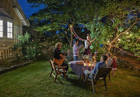 夜晚花园中举办家庭聚会的快乐一家人高清图片下载-正版图片501469003-摄图网